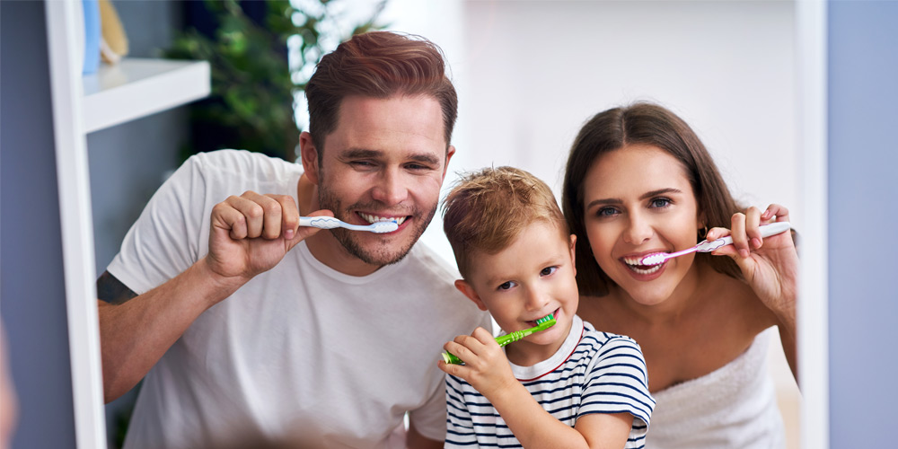 Familia cepillándose los dientes juntos hábitos de higiene bucodental en familia