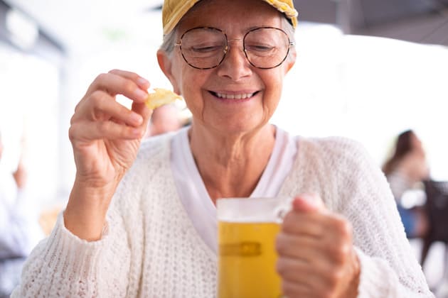 Mujer mayor sosteniendo una cerveza