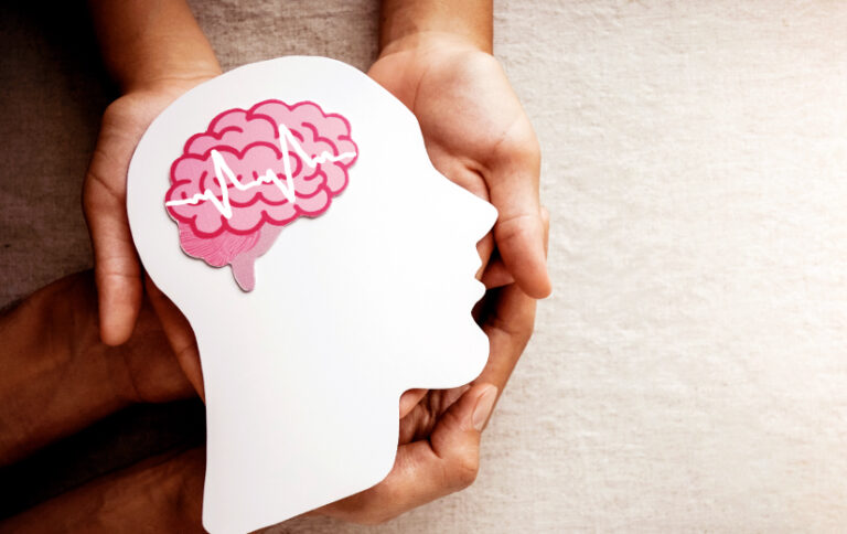 Ilustración de cabeza con cerebro destacado sobre fondo rosa referencia a la salud mental