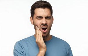 hombre con dolor por desgaste dental