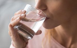 mujer bebiendo agua aliviando papilas gustativas