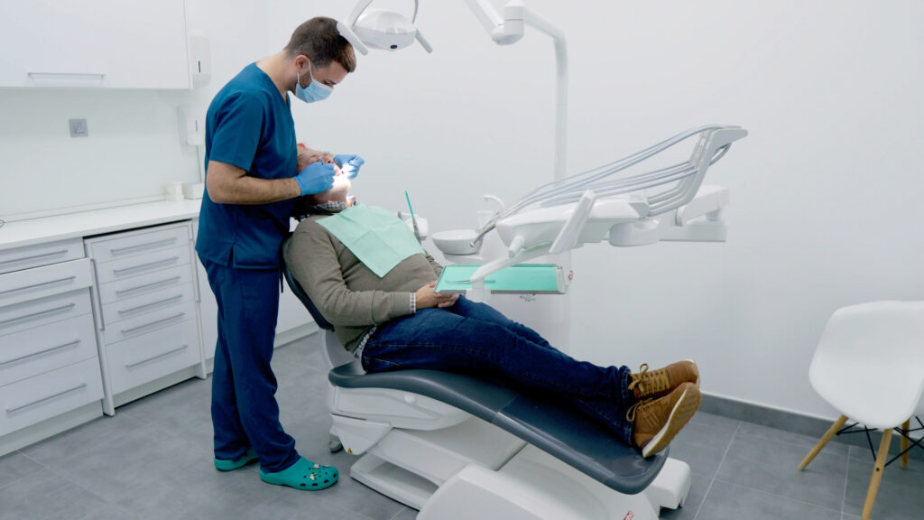 Dentista atendiendo a un paciente en el sillón dental
