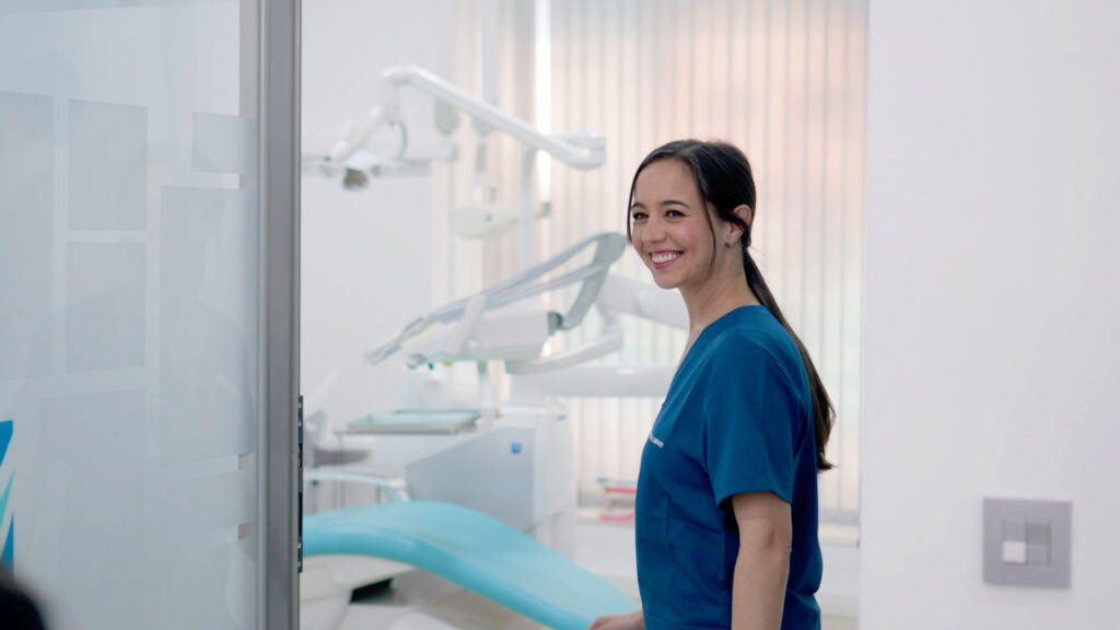 Dentista sonriendo en consulta dental