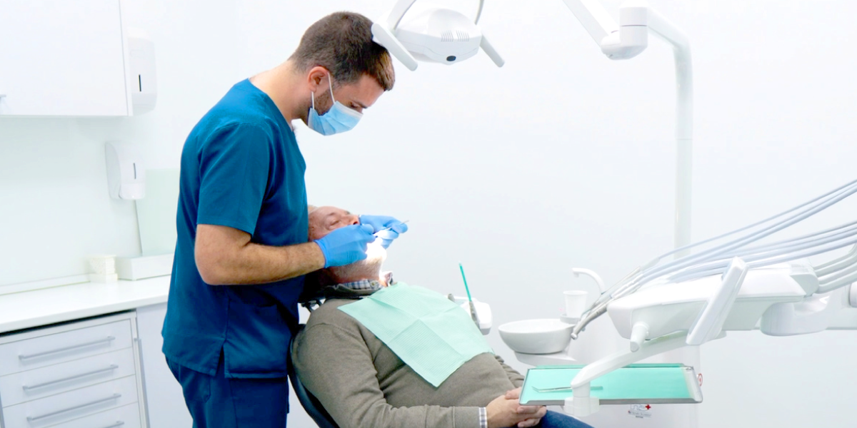 Dentista atendiendo a paciente en sillón dental